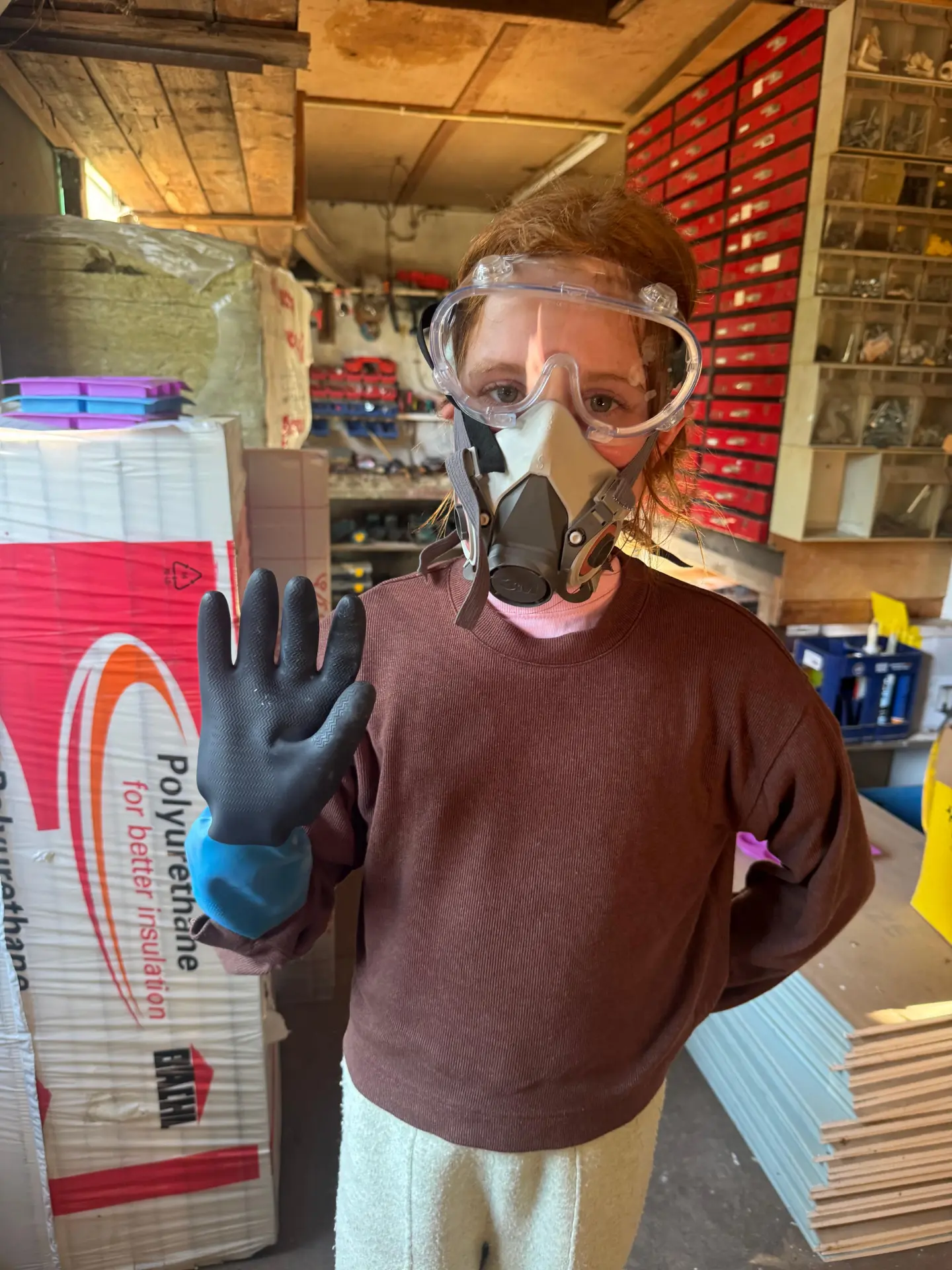 Madeline in het atelier met veiligheidsbril, masker en handschoenen