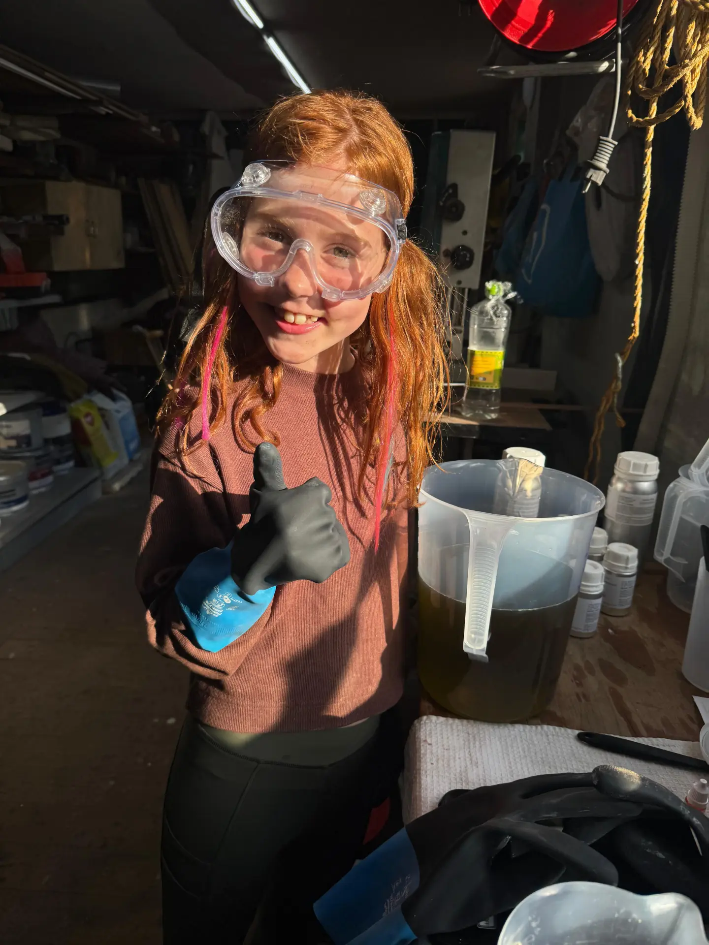 Madeline geeft een duim omhoog naast een kan met gemengde oliën